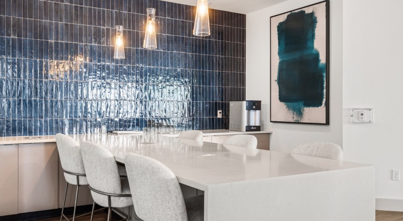 a kitchen with a blue tile backsplash, table and chairs